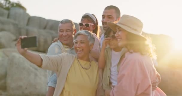 Selfie, Lächeln und Sonnenuntergang mit einer Familie am Strand zusammen im Sommer für Urlaub oder Urlaub. Kinder, Eltern und glückliche Großeltern an der Küste zum Wochenendausflug. - Filmmaterial, Video
