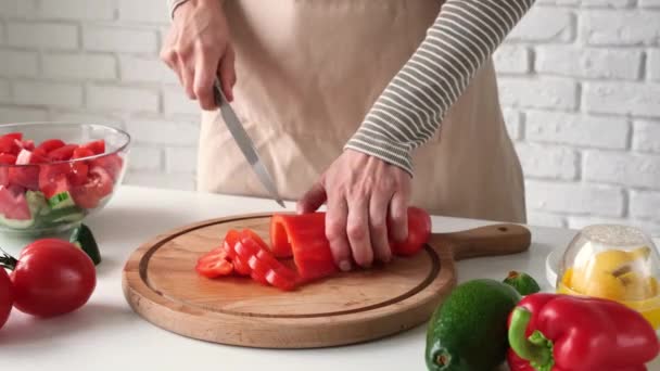 Processo di cottura dell'insalata greca. Donna mani taglio di verdure e l'aggiunta di olive e olio - Filmati, video