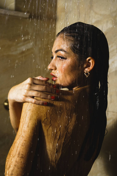 Молодая красивая женщина принимает душ. Концепция ухода за телом - Фото, изображение