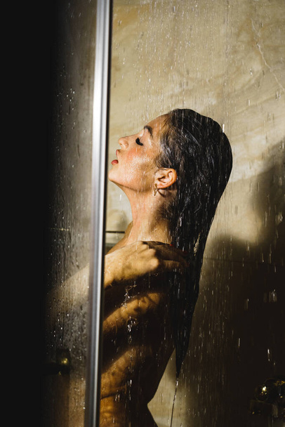 Jeune jolie femme prend une douche. Concept de soins corporels - Photo, image
