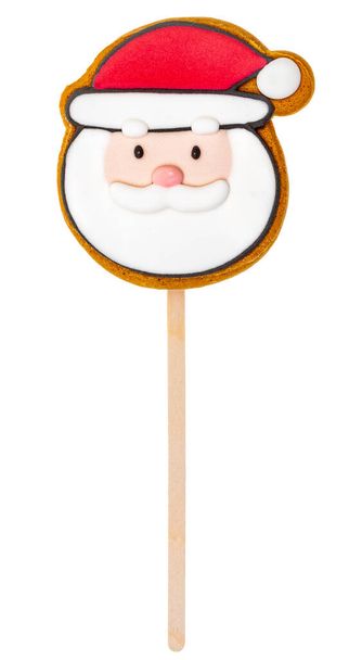Festive Santa Claus-shaped gingerbread cookie pop with colorful icing isolated on a white background - Photo, Image