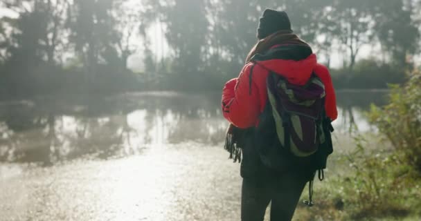 Жінка з рюкзаком, туманом і озером, пішохідні зимові пригоди з миром і прогулянки в спокійній природі. Відпочинок, свобода і дівчина лісовий туман з річкою, деревами і пішохідні подорожі відпочинок у лісі. - Кадри, відео