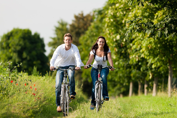 Чоловік і жінка катаються на велосипеді влітку
 - Фото, зображення