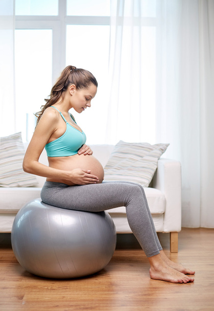 happy pregnant woman exercising on fitball at home - Fotoğraf, Görsel