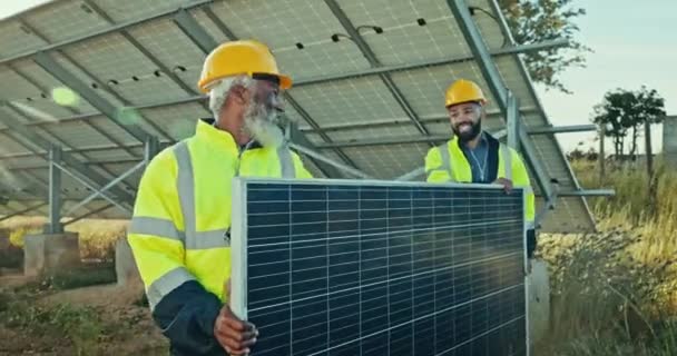 Takım çalışması, temiz enerji santrali ve açık hava elektrik tesislerinde kurulum için güneş panelleri olan adamlar. Sürdürülebilirlik, gülümseme ve teknisyen fotovoltaik güç sisteminde yükleniciye yardım ediyor - Video, Çekim