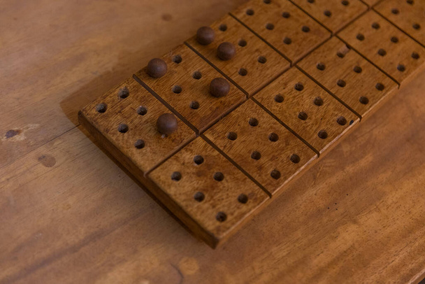 Ξύλινη σανίδα Μπράιγ με μάρμαρα ακουμπισμένη σε ξύλινη επιφάνεια. Έννοια Braille. - Φωτογραφία, εικόνα