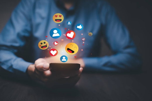 Social media and online digital concept, people online using social media with illustration hologram of emojis showing and floating, social distancing, work from home concept. - Photo, Image