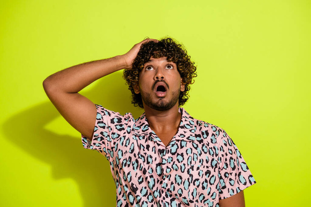 Photo portrait of nice young man look up shocked empty space dressed stylish striped leopard print isolated on yellow color background. - Φωτογραφία, εικόνα