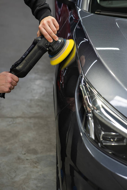 A master polishes the surface of a car body - Φωτογραφία, εικόνα