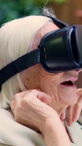 Vídeo de uma mulher velha chocada usando óculos de realidade virtual em um geriátrico - Filmagem, Vídeo