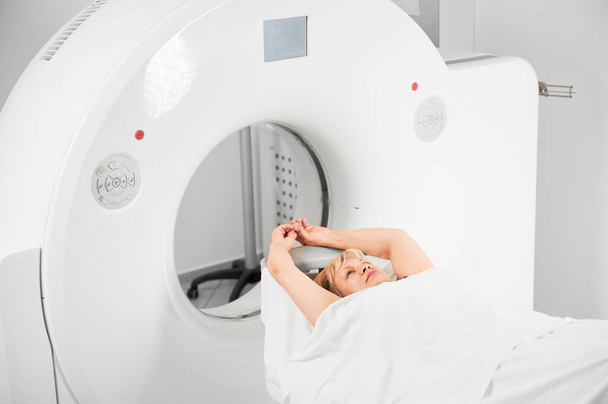 Tıbbi bilgisayarlı tomografi ya da MRI tarayıcısı. Kadın hasta kanepede uzanıyor, doktoru bekliyor. Tıp, sağlık ve modern teşhis kavramı. - Fotoğraf, Görsel