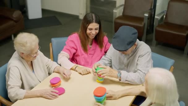 Video de un hombre mayor resolviendo un complicado juego de habilidad en una geriatría y la gente lo felicita - Metraje, vídeo