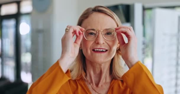 Optométrie, lunettes et visage de la femme âgée dans une clinique pour la vision, les soins oculaires ou la santé avec une attitude positive. Heureux, sourire et portrait de femme mexicaine avec des lunettes en magasin optique - Séquence, vidéo
