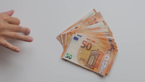 een meisje hand close-up op een witte achtergrond houdt een hand verspreid euro 's voor 50. met rechts is er een plaats voor de inscriptie mooie geld achtergrond. Hoge kwaliteit 4k beeldmateriaal - Video