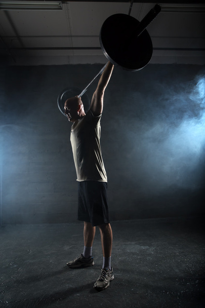 Athlete performs a barbell exercise - Photo, image