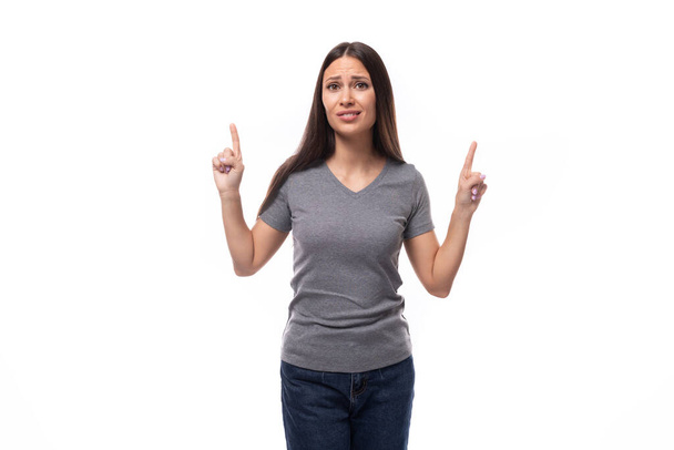giovane donna promoter bruna sottile con capelli lunghi dritti vestita con una t-shirt di base grigia con stampa mockup. concetto uniforme. - Foto, immagini