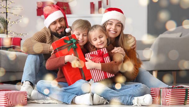 Padres felices y sus hijos pequeños con regalos de Navidad en casa - Foto, imagen