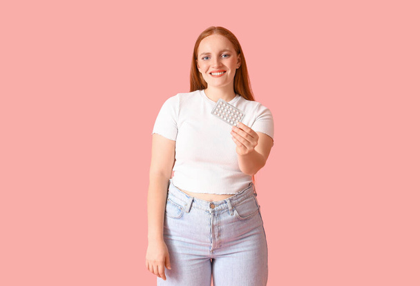 Young woman with contraceptive pills on pink background - Photo, Image