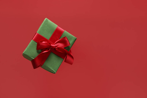 Літаюча подарункова коробка на червоному тлі - Фото, зображення