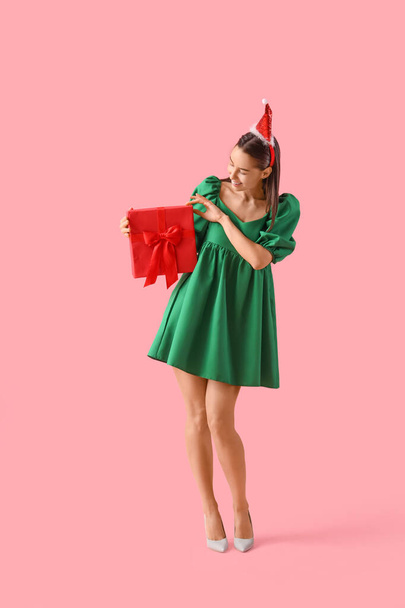 Kaunis nainen Santa hattu joululahja vaaleanpunainen tausta - Valokuva, kuva