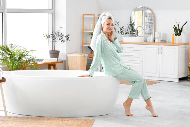 Mooie vrouw na douche zittend op bad thuis - Foto, afbeelding