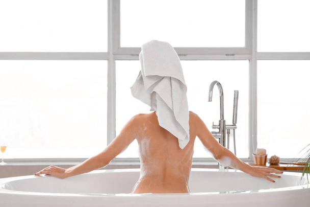 Красива жінка приймає ванну вдома, вид ззаду - Фото, зображення
