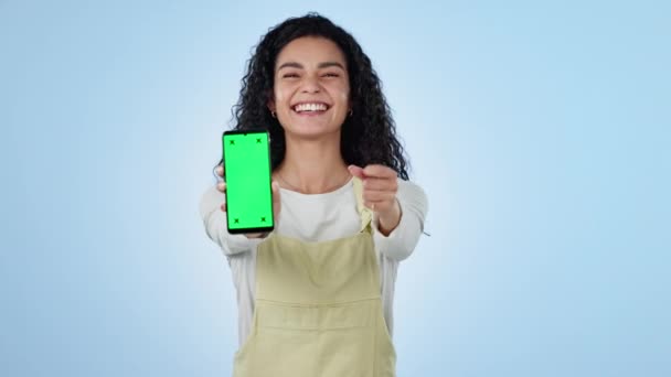 Γυναίκα, τηλέφωνο πράσινη οθόνη και τους αντίχειρες για το μάρκετινγκ, συνδρομή και μελέτη ή την ευκαιρία μάθησης στο στούντιο. Πρόσωπο ενθουσιασμένου μαθητή που δείχνει προς την εφαρμογή για κινητά και δείκτες εντοπισμού σε μπλε φόντο. - Πλάνα, βίντεο