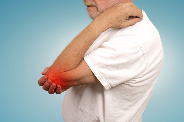 ανώτερος άνθρωπος με φλεγμονή του αγκώνα χρωματισμένος με κόκκινο χρώμα που πάσχουν από τον πόνο  - Φωτογραφία, εικόνα