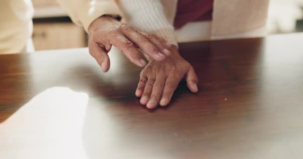 Starsza para, stół i trzymanie się za ręce w opiece, miłość lub wsparcie razem dla zaufania i współczucia w domu. Zbliżenie starszego mężczyzny i kobiety do raka empatii, pomocy w żałobie lub wygody na drewnianym biurku. - Materiał filmowy, wideo