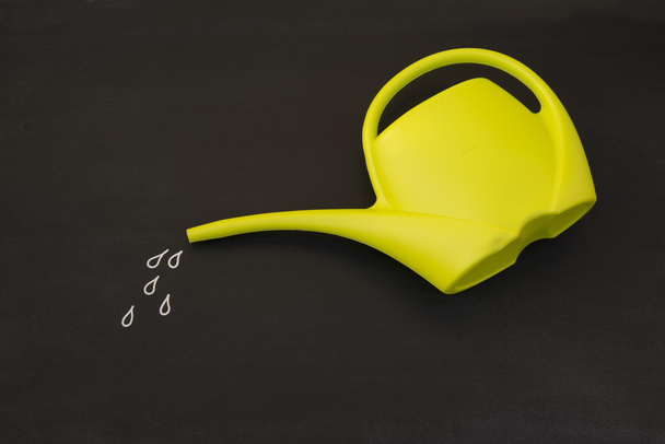 Watering can in front of blackboard - Photo, Image