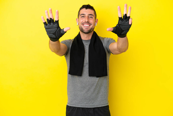 Jeune homme caucasien sportif isolé sur fond jaune comptant neuf avec les doigts - Photo, image
