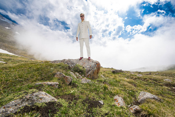  άνδρας με λευκό κοστούμι σε ένα βουνό - Φωτογραφία, εικόνα