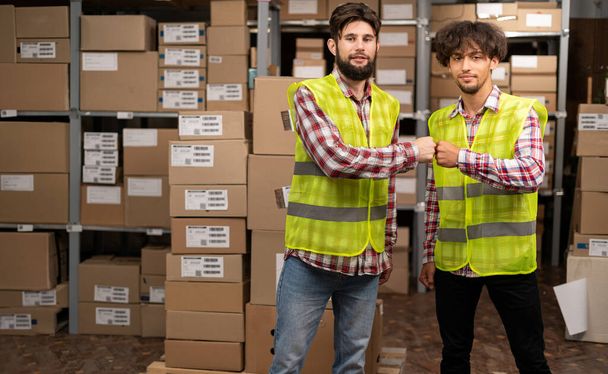 Warehouse worker giving high five to his friend colleague. Workers high five done job in warehouse. Copy space - Photo, Image