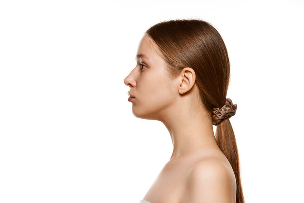Profile view portrait of beautiful young woman with bare shoulders, well-kept spotless skin isolated white studio background. Skin care cosmetic treatment. Concept youth, natural beauty. Ad - Photo, Image
