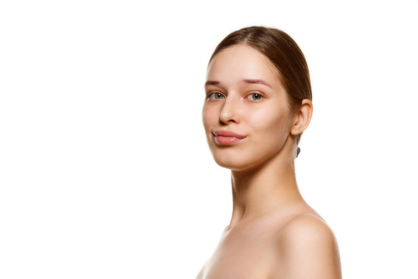 Ritratto di bella giovane donna con spalle nude, pelle immacolata ben tenuta guardando la fotocamera isolata sfondo bianco. Cura della pelle trattamento cosmetico. Concetto gioventù, bellezza naturale. Pubblicità - Foto, immagini