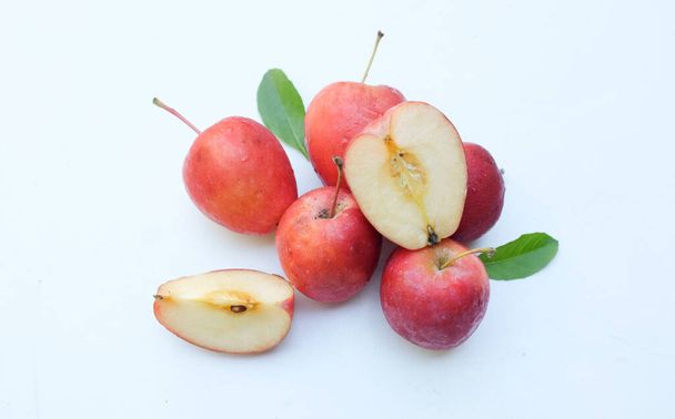 Grupo de manzana enana roja-amarilla madura orgánica fresca, manzanas princesa, manzana, mini manzana, manzana pequeña, manzana cereza, manzanas rojas brillantes Manzana entera, mitad y una rebanada con hoja verde sobre un fondo blanco - Foto, imagen