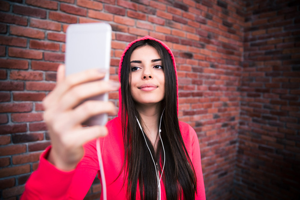 Happy young sportive woman looking on smartphone - Foto, imagen