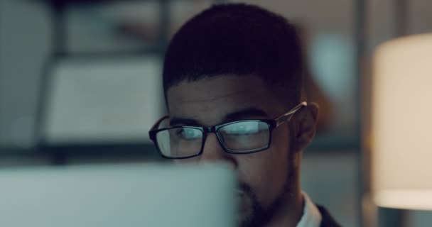 Business, computer and black man reading, writer and focus on project at night. Desktop, concentration glasses and African male professional read email, information or copywriting for office deadline. - Footage, Video