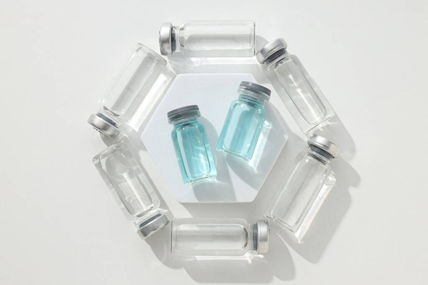 Frascos médicos de vidrio con vacuna sobre fondo blanco, vista superior - Foto, Imagen