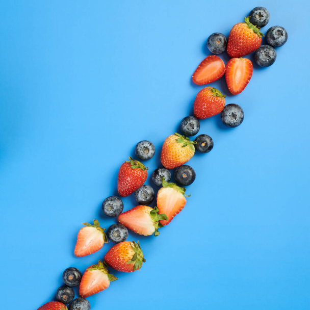 Čerstvé jahody a borůvky na modrém pozadí - Fotografie, Obrázek