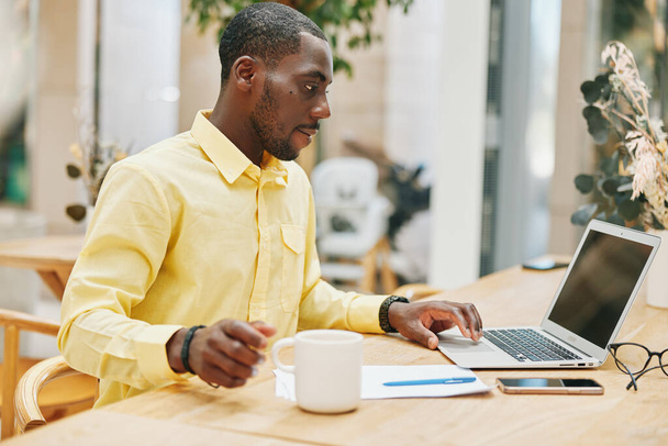 Чоловік робота підприємець сидить на роботі менеджер офіс сучасна людина розумний комп'ютерний стіл портрет стиль життя молодий професійний ноутбук чоловічий бізнесмен чорношкірий африканський бізнес - Фото, зображення