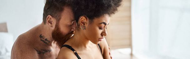banner of diverse couple, bearded man and african american woman sharing a tender moment on bed - Photo, Image