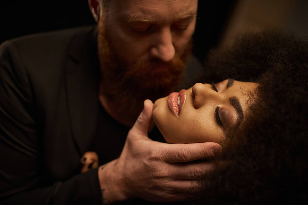 brodaty mężczyzna uwodzi piękny afrykański amerykański kobieta z kręcone włosy, intymny moment sexy para - Zdjęcie, obraz