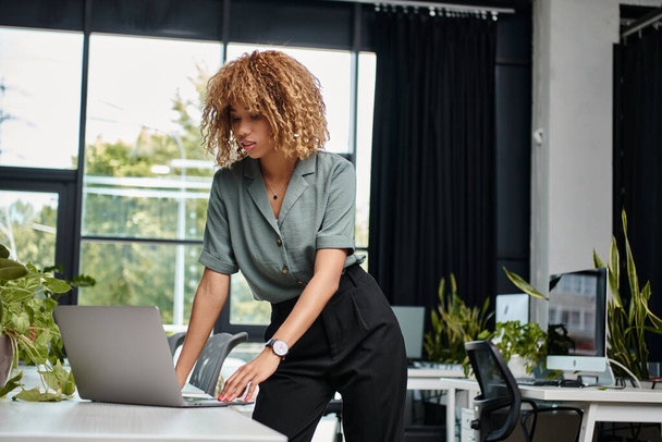 Envolvido no trabalho jovem afro-americano profissional usando laptop em uma mesa de escritório bem iluminada - Foto, Imagem