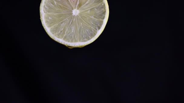 Druipend sap van een vers gesneden citroenschijfje. Vallende druppel citroensap slow motion. - Video