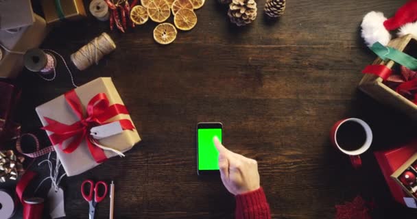 Joulu, lahja ja puhelin vihreä ruutu käsissä paketti tai laatikko ja mockup tilaa. Edellä puinen pöytä henkilö älypuhelin loma toivelista, luova verkkokauppa sovellus tai verkkokaupoissa myynti. - Materiaali, video
