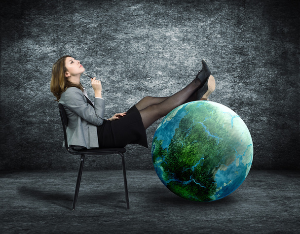Träumende Geschäftsfrau stellt ihre Füße auf den Globus. - Foto, Bild