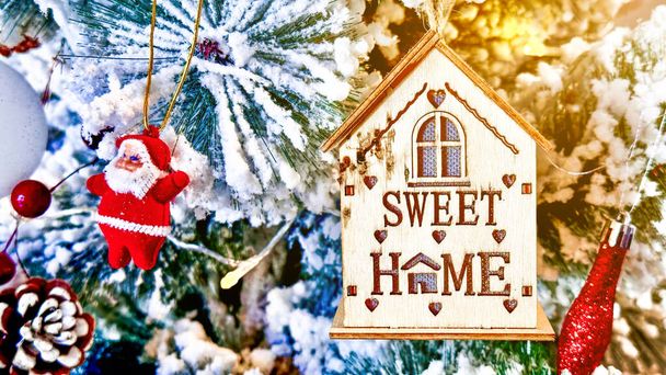 Маленький прикрашений будинок з текстом солодкий будинок, що висить на гілці штучного дерева концепція перебування вдома святкувати Різдво з сім'єю - Фото, зображення