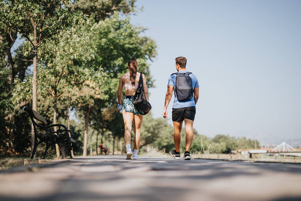 Motivovaný pár se věnuje outdoorovému cvičení, cvičí ve slunečném parku. S vytrvalostí usilují o lepší kondici a tvar těla, těší se z přírodního prostředí a čerstvého vzduchu. - Fotografie, Obrázek