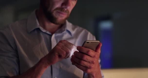 Night at work, businessman with smartphone and search online for email, website or social media post. Internet, scroll and networking, professional man checking mobile app on phone in dark office - Footage, Video